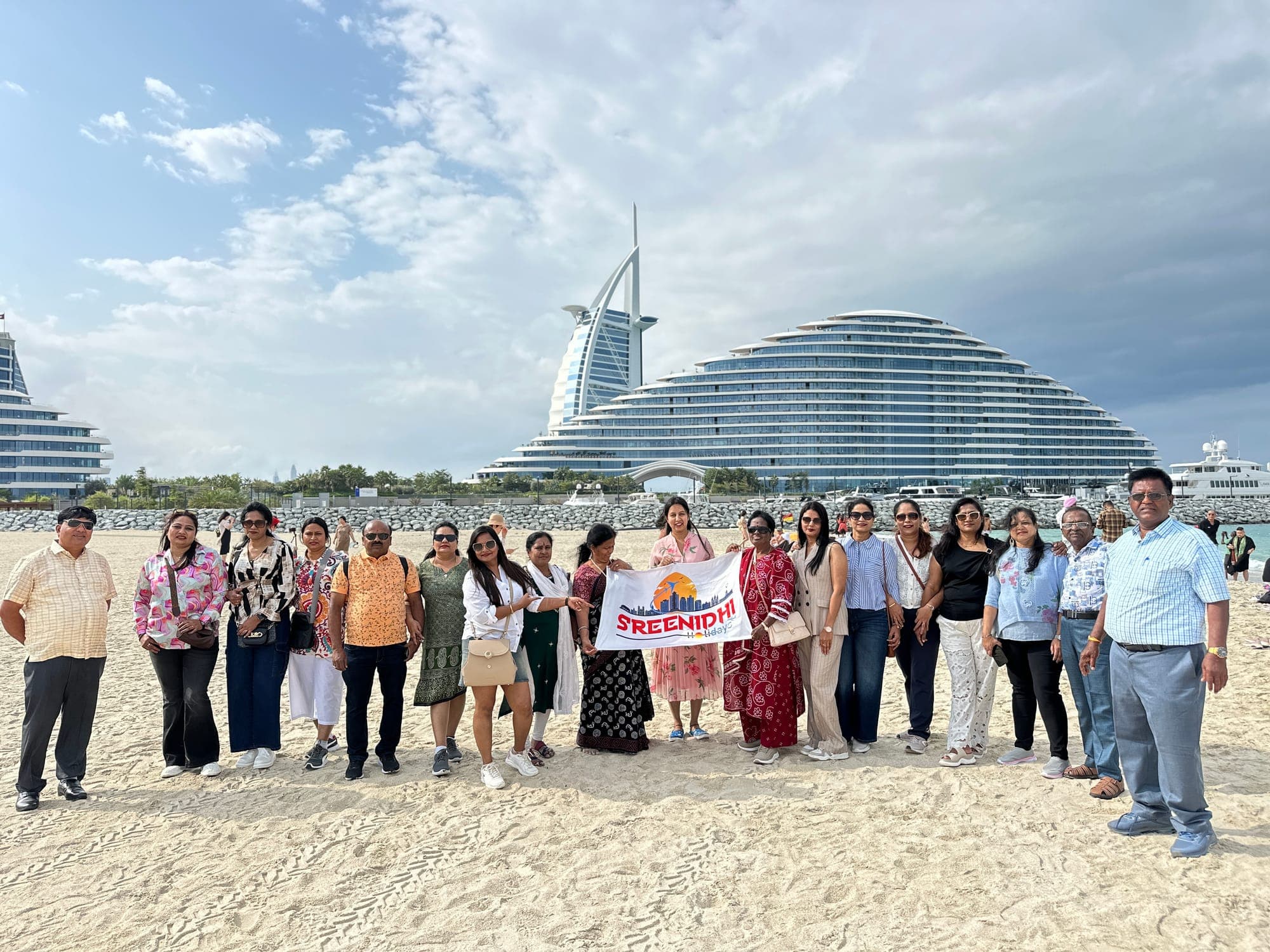 Large Sreenidhi Holidays group on the beach by the Burj Al Arab, Dubai
