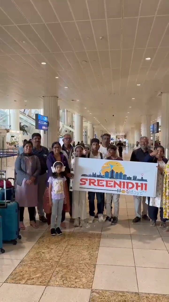 Sreenidhi Holidays group with the banner at the airport